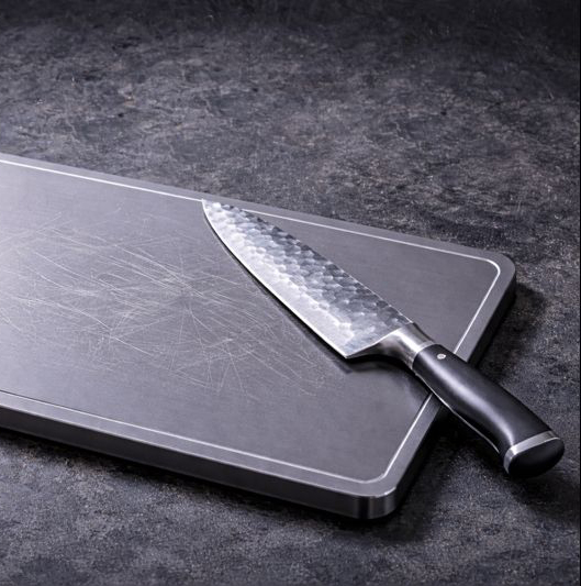 worn chefs knife on titanium cutting board
